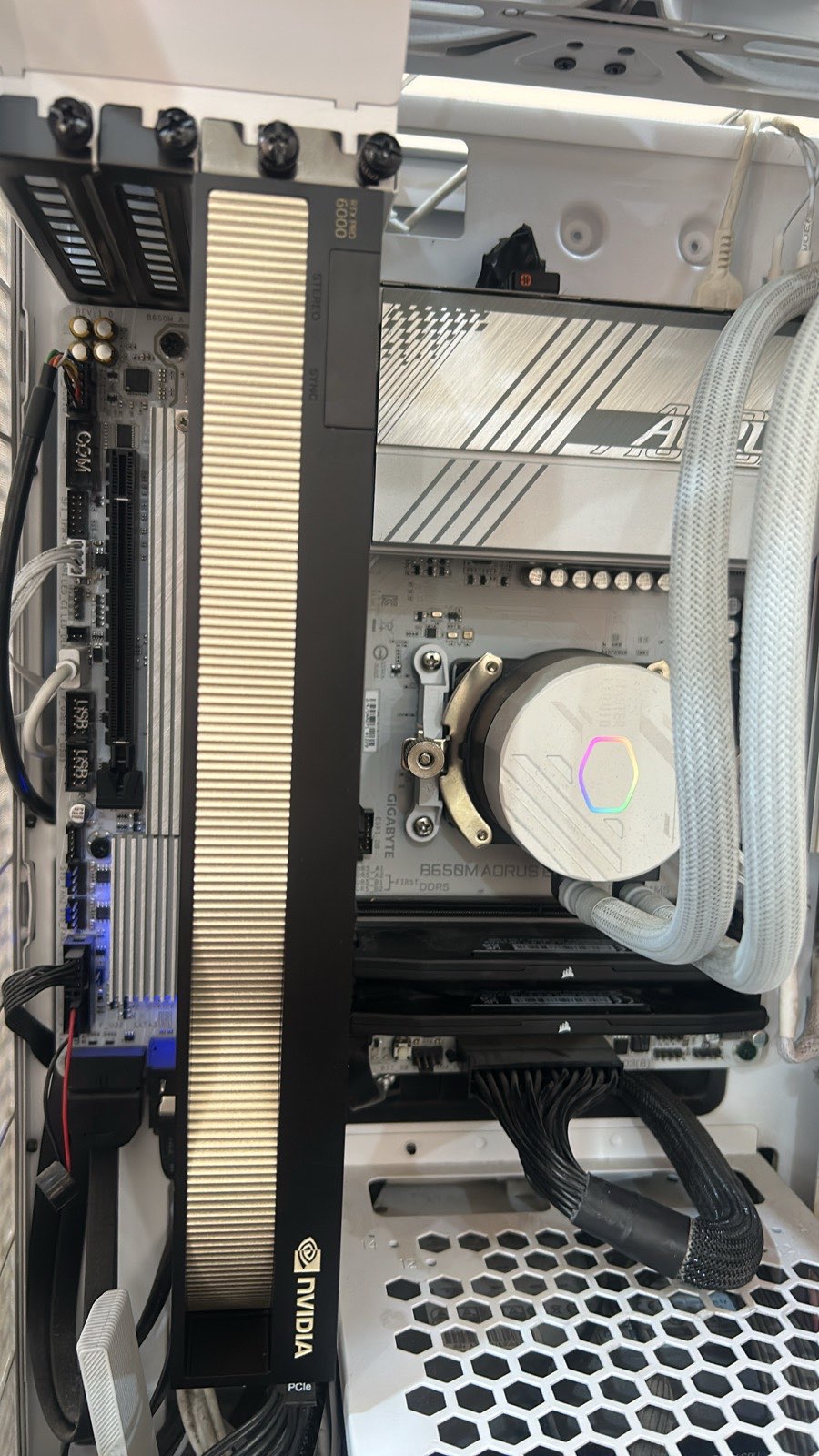 Close-up of the RTX PRO 6000 GPU's heatsink inside the build, next to the AORUS motherboard and the CPU's liquid-cooling pump
